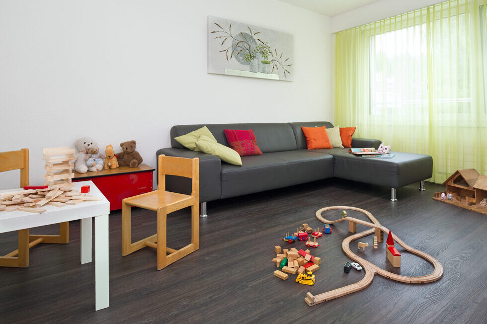 Wohnzimmer mit Tisch Couch und Spielsachen