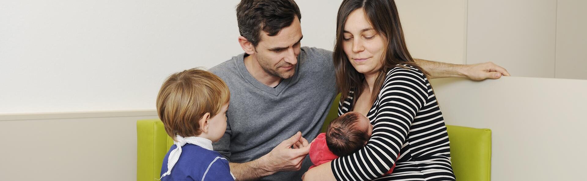 Junge Familie mit Baby auf einem Sofa