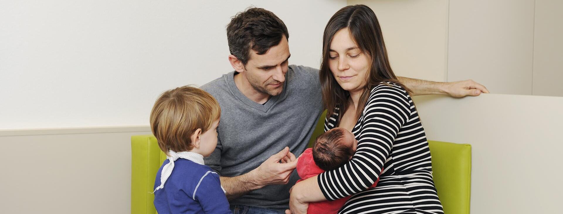 Junge Familie mit Baby auf einem Sofa