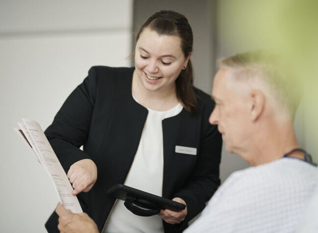 Guest Relation: Mitarbeiterin berät bei der Menüauswahl.