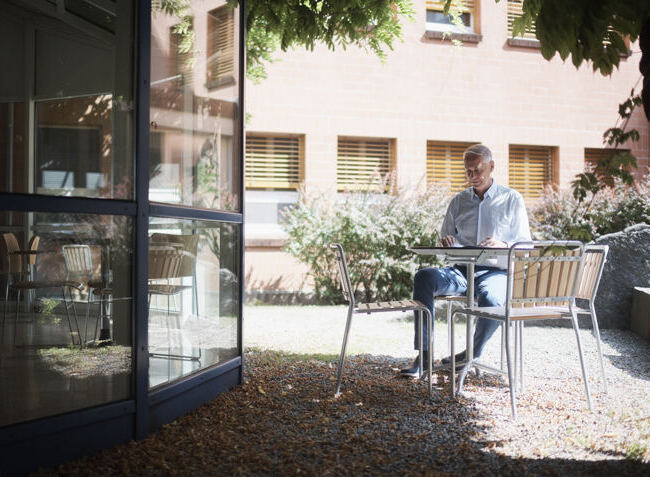 Patient sitzt im Innenhof.