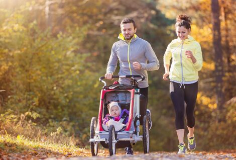 Junges Paar beim Joggen mit Babywagen